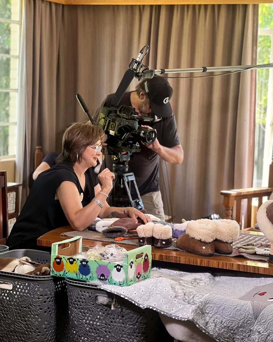 Rika stitching sheepskin slippers while being filmed